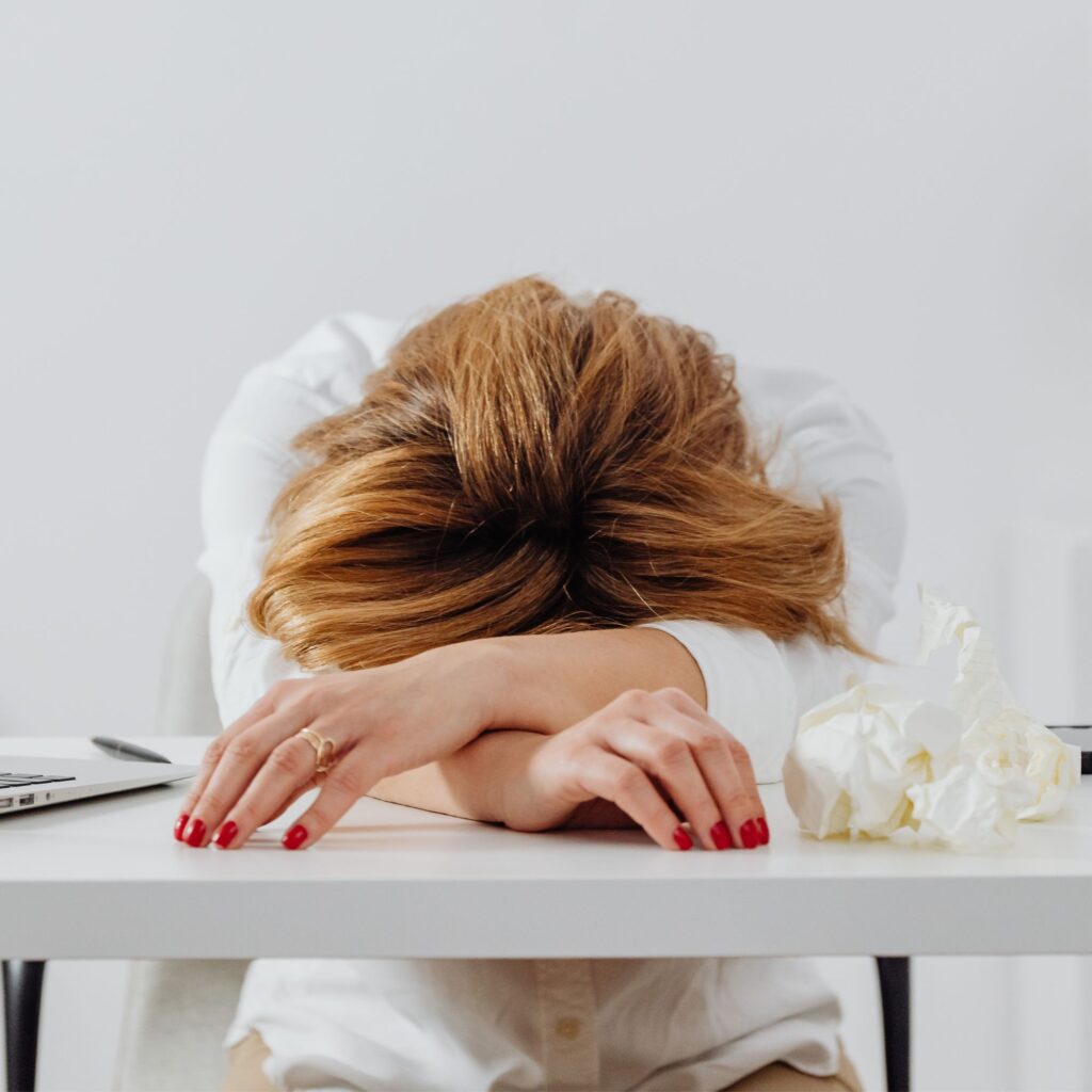 Mujer descansa sobre sus brazos en señal de cansancio.